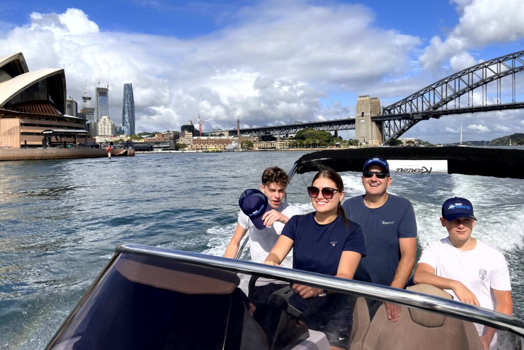 Family enjoying their Ranieri Voyager out on the Sydney Harbour with the Opera House and Sydney Harbour bridge in the background.