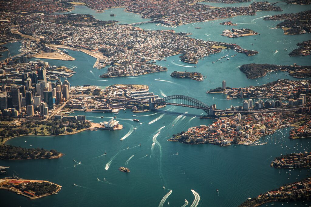 Busy aerial view of Sydney Harbour with many boats, Sydney Harbour Bridge and Opera House.